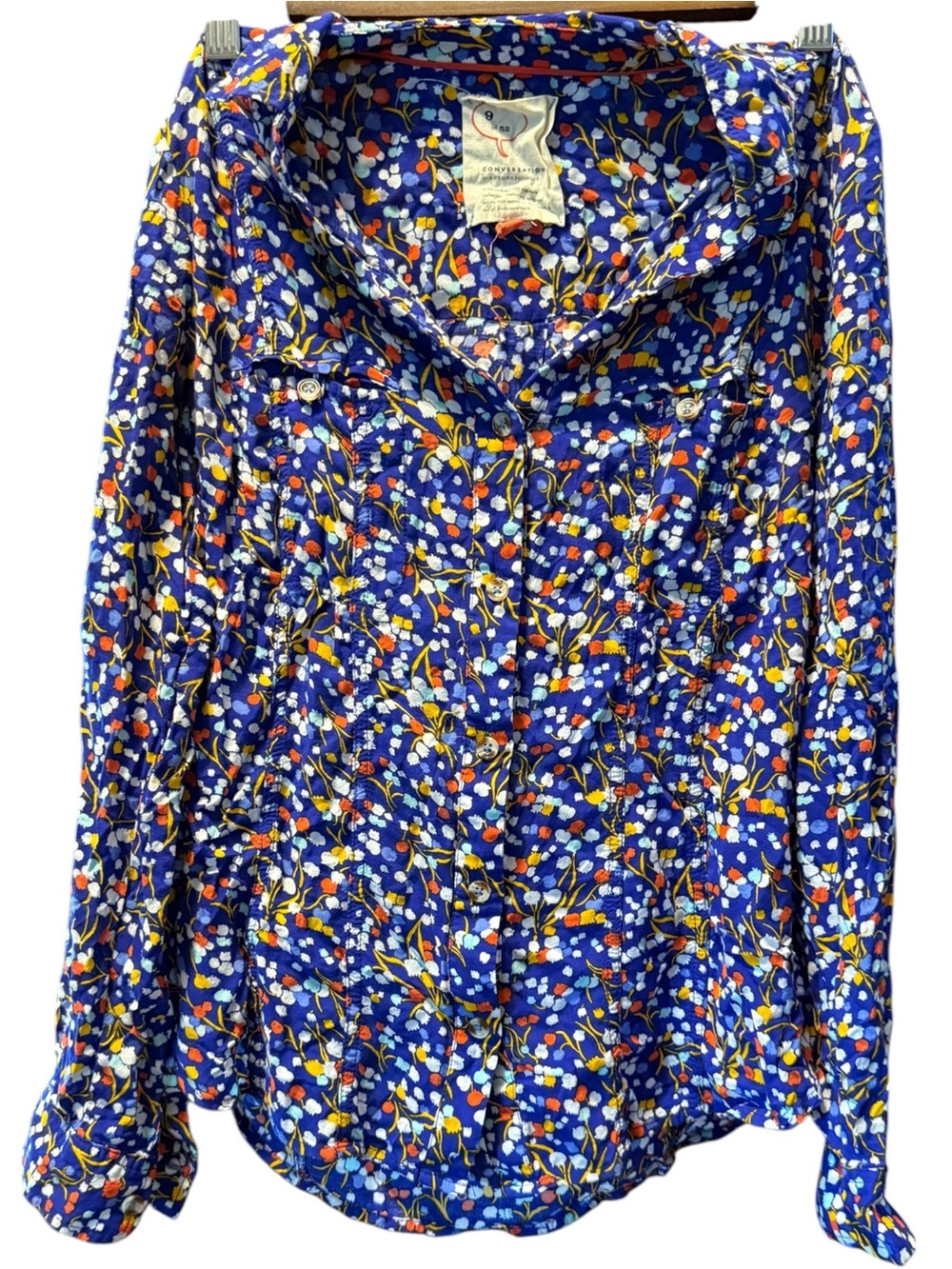 Anthropologie blue button-down blouse featuring a "Pop Potpourri" floral print.